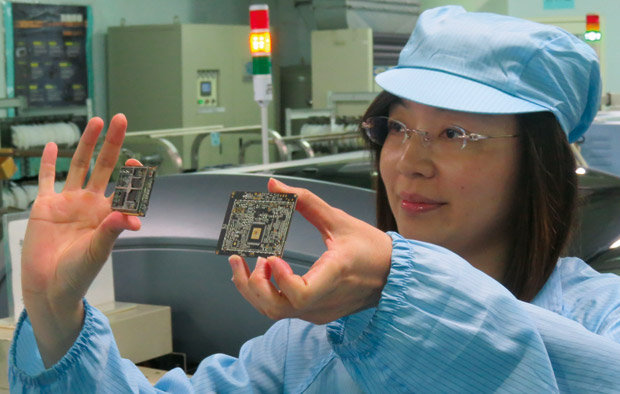 Funcionária de fábrica de acessórios automotivos de Taiwan exibe circuitos eletrônicos