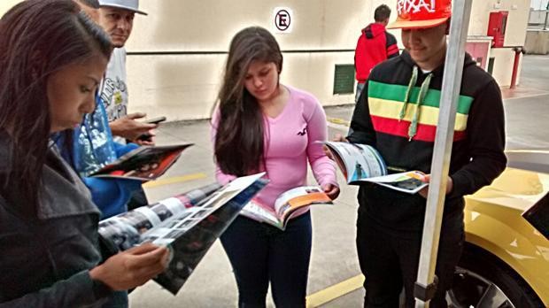 Visitantes do evento do Grupo SQ folheiam exemplares da Revista AutMOTIVO, especializada em som e acessórios automotivos